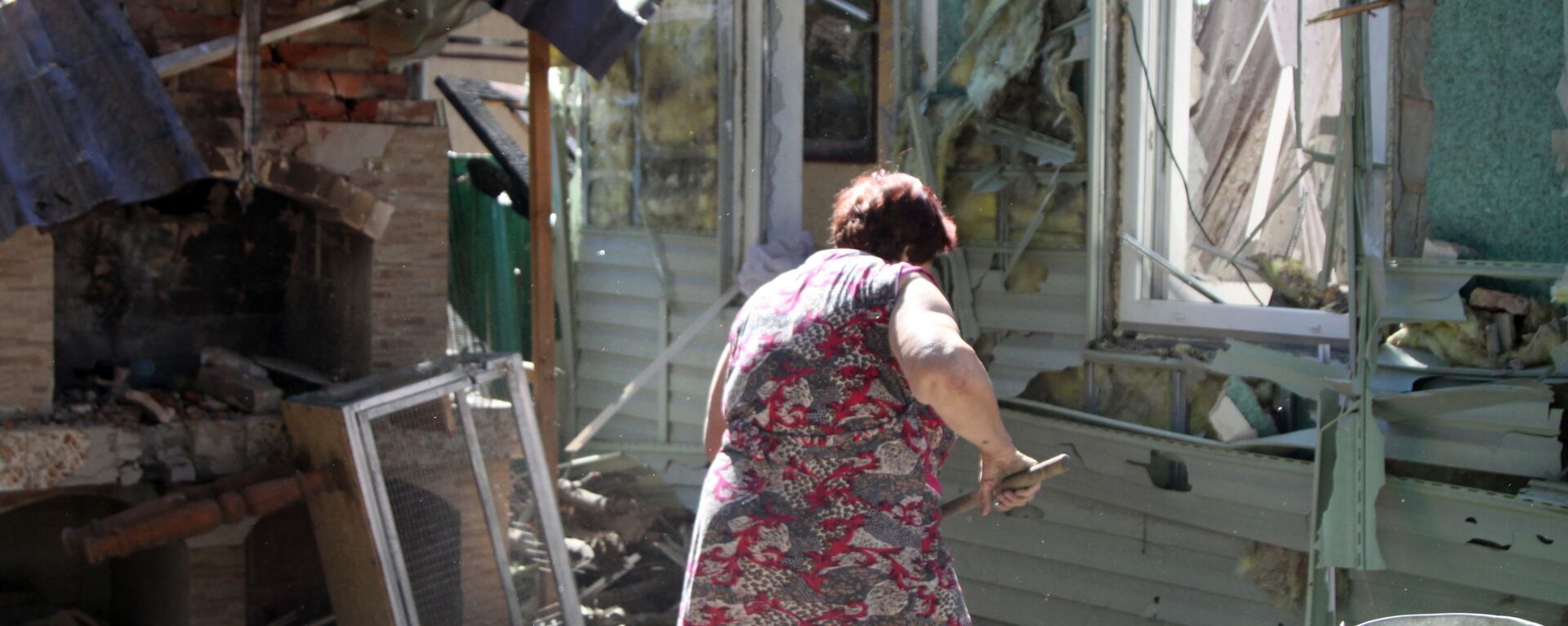 Женщина убирает мусор во дворе жилого дома в Донецке, пострадавшего в результате обстрела - Sputnik Ўзбекистон, 1920, 24.08.2021