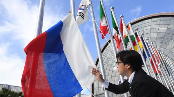 Вывешивание флага России у международного выставочного центра INTEX Osaka перед открытием саммита Группы двадцати в японской Осаке - Sputnik Ўзбекистон