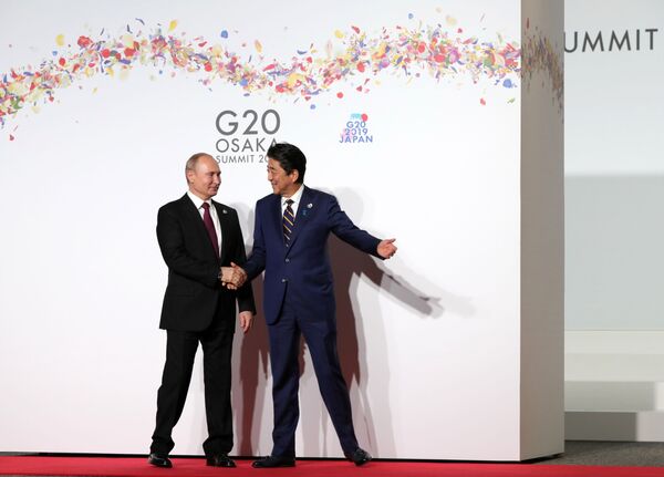 Президент РФ Владимир Путин и премьер-министр Японии Синдзо Абэ на церемонии официальной встречи участников саммита Группы двадцати в международном выставочном центре INTEX Osaka - Sputnik Узбекистан