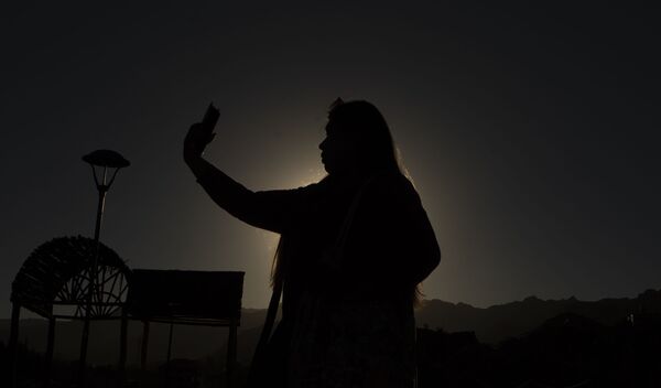 Женщина фотографируется во время солнечного затмения в Боливии - Sputnik Ўзбекистон