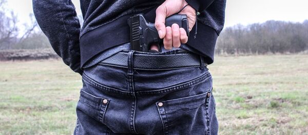 Мужчина держит пистолет. Иллюстративное фото Мужчина держит пистолет. Иллюстративное фото - Sputnik Ўзбекистон