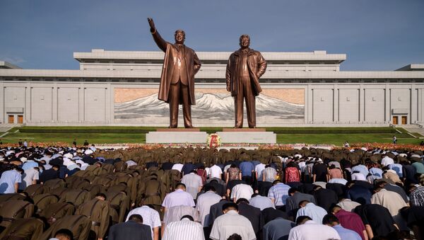 Жители Пхеньяна во время минуты молчания у памятника Ким Ир Сену и Ким Чен Иру в день отмечания 25-летия со дня смерти Ким ИМ Сена - Sputnik Ўзбекистон