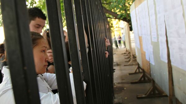 Абитуриенты стоят возле ограждения - Sputnik Узбекистан