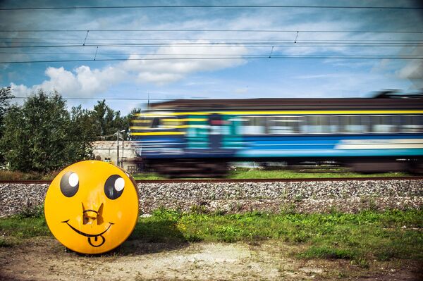 Эмодзи у проходящего поезда в Таллине - Sputnik Узбекистан