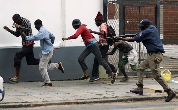 Полицейский разгоняет демонстрантов на антимигрантском митинге в Претории, ЮАР. - Sputnik Узбекистан