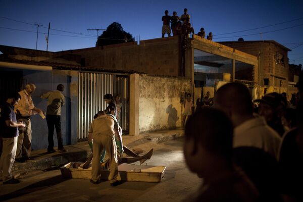 Работники морга забирают тело мужчины, погибшего во время стрельбы в районе Итинга в Сальвадоре, Бразилия. - Sputnik Узбекистан