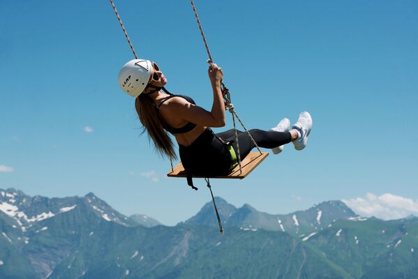 Девушка катается на тарзанке на горнолыжном курорте Роза Хутор в Сочи - Sputnik Узбекистан