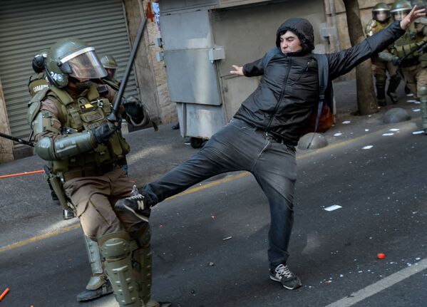 Столкновения демонстрантов с полицией во время митинга в ознаменование 46-й годовщины военного переворота во главе с генералом Аугусто Пиночетом, Чили - Sputnik Узбекистан