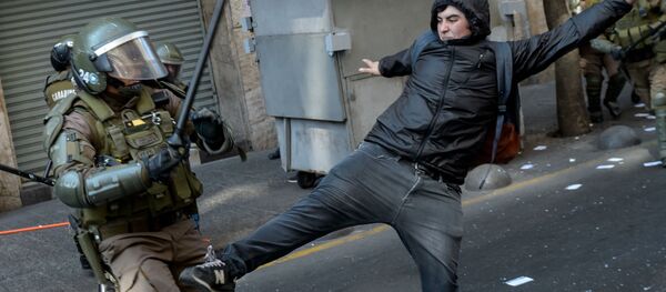 Столкновения демонстрантов с полицией во время митинга в ознаменование 46-й годовщины военного переворота во главе с генералом Аугусто Пиночетом, Чили - Sputnik Узбекистан