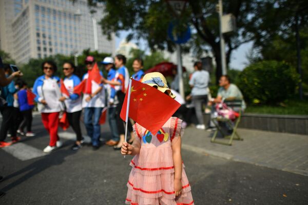Девочка с китайским флагом на военном параде в честь 70-летия образования КНР в Пекине - Sputnik Узбекистан