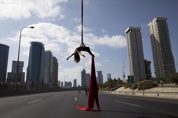 Израильская акробатка выступает на шоссе во время еврейского праздника Yom Kippur в Тель-Авиве, Израиль - Sputnik Узбекистан