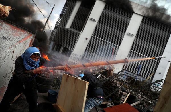 Демонстрант стреляет из самодельного оружия во время протеста в Кито, Эквадор - Sputnik Узбекистан