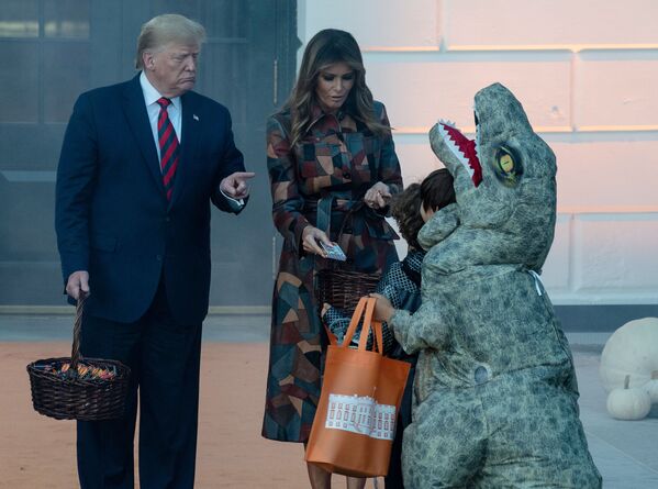 Президент США Дональм Трамп с женой во время раздачи сладостей детям в Белом доме в честь Хеллоуина - Sputnik Узбекистан