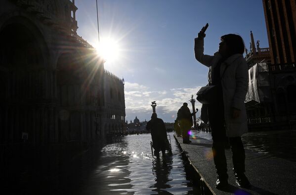 Турист на площади Сан-Марко во время наводнения в Венеции - Sputnik Узбекистан