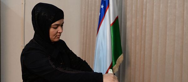 Женщина голосует на избирательном участке - Sputnik Узбекистан