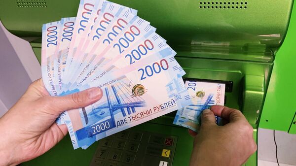 Клиент Сбербанка вносит наличные деньги в банкомат - Sputnik Узбекистан