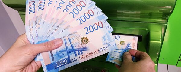 Клиент Сбербанка вносит наличные деньги в банкомат Клиент Сбербанка вносит наличные деньги в банкомат - Sputnik Ўзбекистон