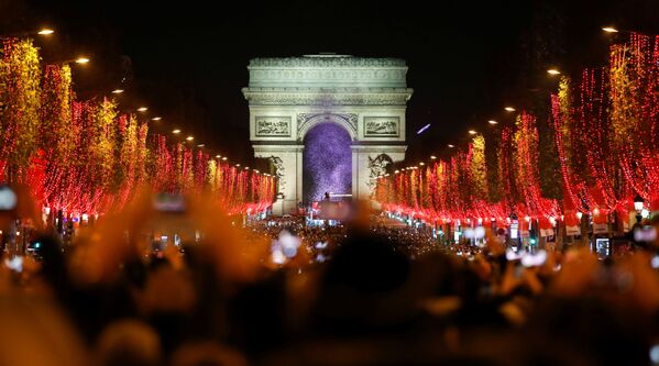 Зрители во время праздничного светового шоу перед Триумфальной аркой в Париже - Sputnik Узбекистан