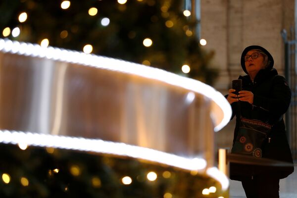 Женщина фотографирует новогоднюю елку в Палаццо Колонна в Риме - Sputnik Узбекистан