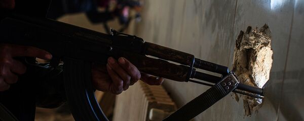 Автомат в руках члена незаконного вооруженного формирования - Sputnik Узбекистан