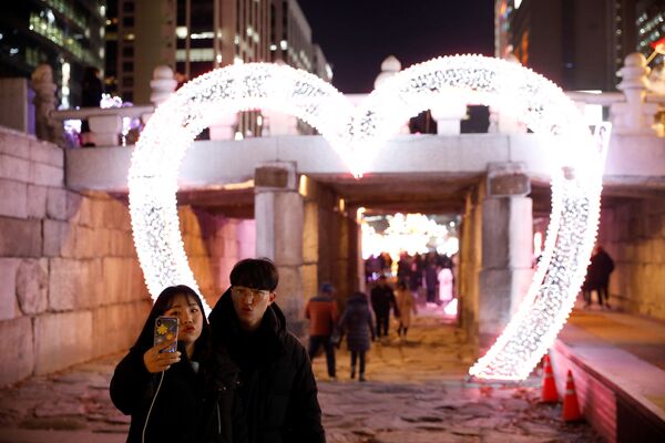 Vlyublennaya para vo vremya fotografirovaniya nakanune Novogo goda v Seule, Yujnaya Koreya  - Sputnik O‘zbekiston