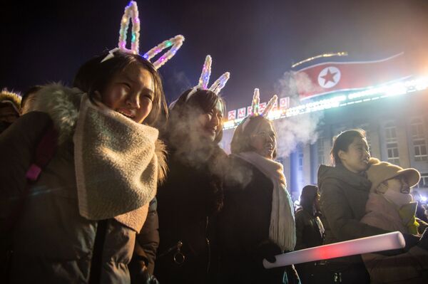 Девушки смотрят запуск салюта во время празднования Нового года в КНДР  - Sputnik Ўзбекистон