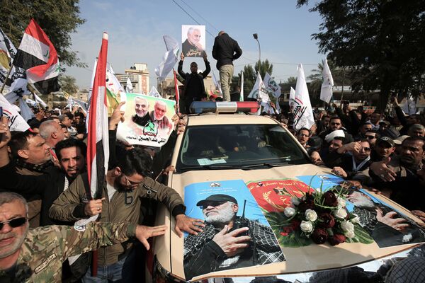 Машина с изображениями иракского военного Абу Махди аль-Мухандис во время похоронной церемонии в Багдаде - Sputnik Узбекистан