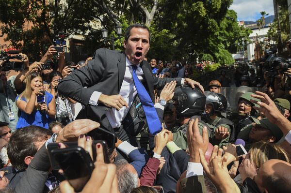 Самопровозглашенный исполняющий обязанности президента Венесуэлы Хуан Гуайдо в окружении журналистов по пути в Национальное собрание, Каракас - Sputnik Узбекистан