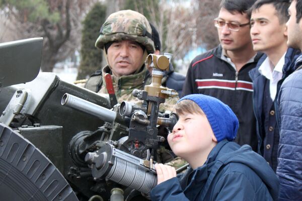 Ребенок смотрит в прицел артилерейской пушки - Sputnik Узбекистан