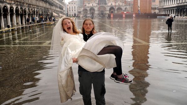 Жених с невестой на руках во время наводнения в Венеции  - Sputnik Узбекистан