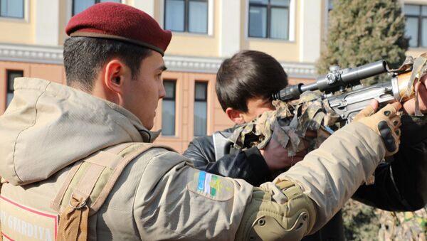 Военнослужащий национальной гвардии Узбекистана знакомит молодого человека со снайперской винтовкой - Sputnik Узбекистан