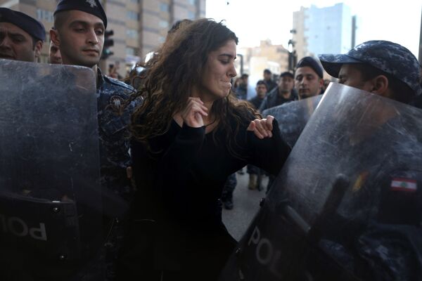 Участница протестов и ливанские полицейские в Бейруте - Sputnik Узбекистан