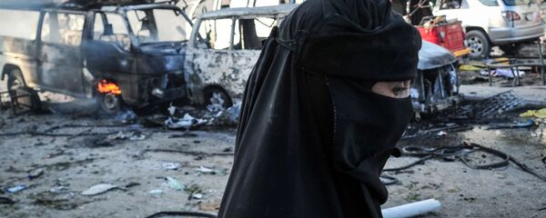 Женщина-мусульманка на фоне сгоревших машин. Иллюстративное фото - Sputnik Узбекистан