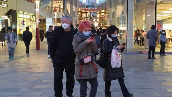 Прохожие в защитных масках на одной из улиц в Пекине - Sputnik Ўзбекистон