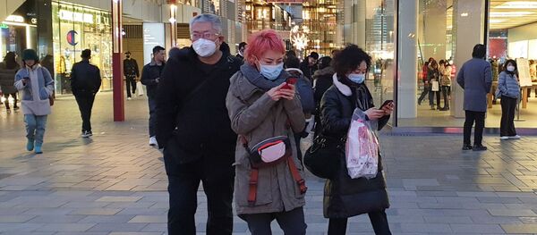 Прохожие в защитных масках на одной из улиц в Пекине - Sputnik Ўзбекистон