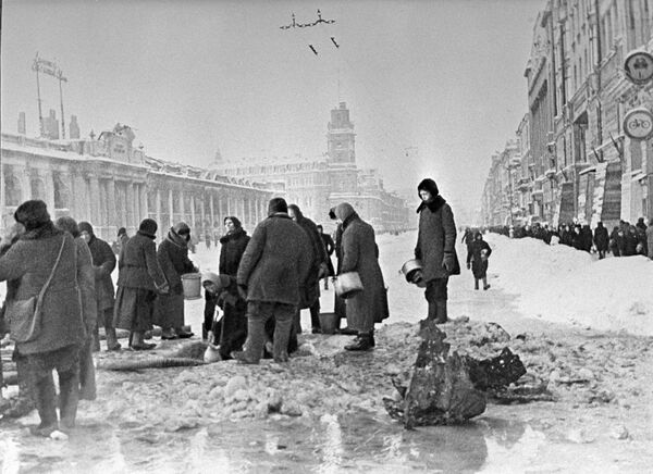 Жители блокадного Ленинграда набирают воду, появившуюся после артобстрела в пробоинах в асфальте,  - Sputnik Узбекистан