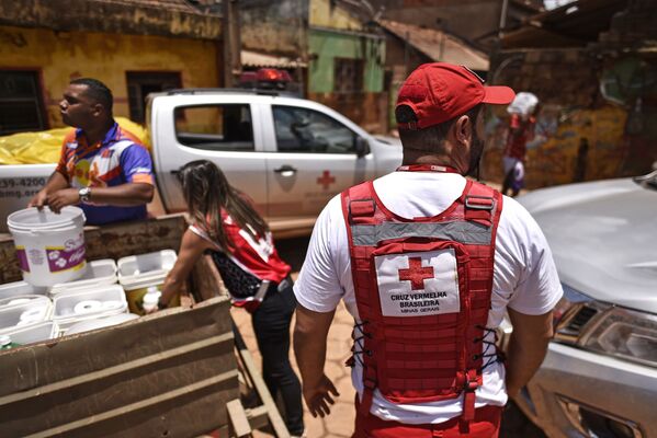  Члены Бразильского Красного Креста раздают воду и моющие средства местным жителям после наводнения в бразильском Белу-Оризонти - Sputnik Узбекистан