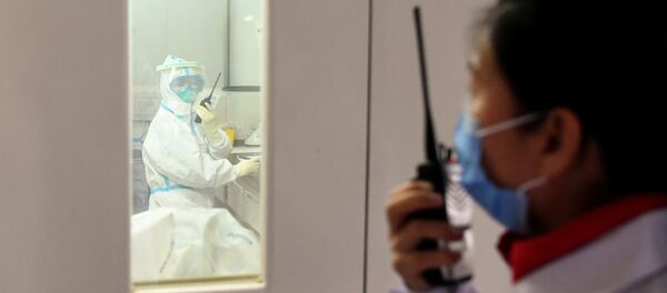 Сотрудник центра по профилактике и борьбе с коронавирусам общается через рацию с коллегой Сотрудник центра по профилактике и борьбе с коронавирусам общается через рацию с коллегой - Sputnik Ўзбекистон