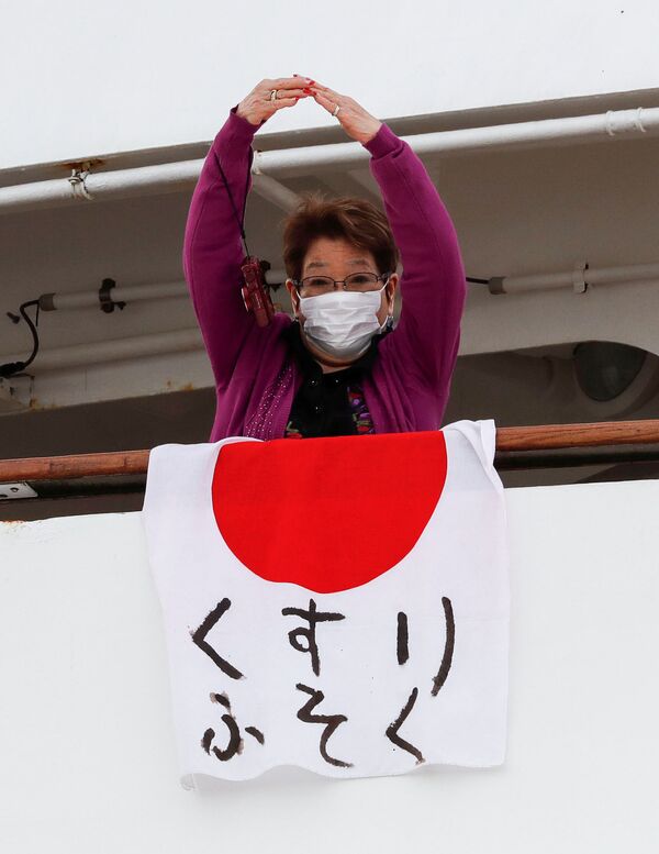 Пассажирка в медицинской маске на борту круизного лайнера Diamond Princes, помещенного в карантин у японского порта Йокогама - Sputnik Узбекистан