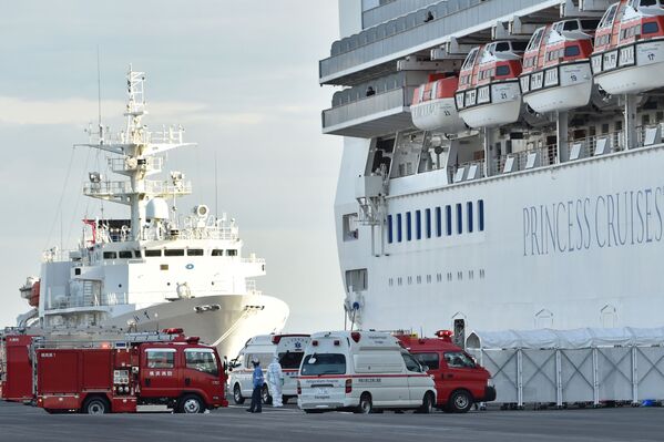 Пожарные машины и кареты скорой помощи у круизного лайнера Diamond Princes, помещенного в карантин у японского порта Йокогама - Sputnik Узбекистан