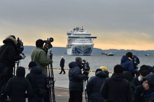 Фотографы и корреспонденты на фоне круизного лайнера Diamond Princes, помещенного в карантин у японского порта Йокогама - Sputnik Узбекистан