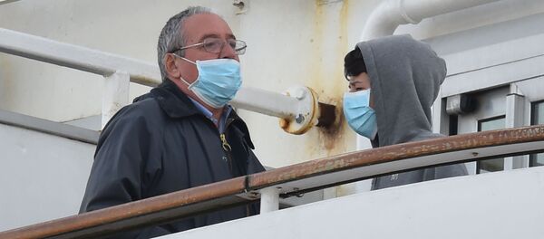 Пассажиры в медицинских масках на борту круизного лайнера Diamond Princes, помещенного в карантин у японского порта Йокогама - Sputnik Узбекистан