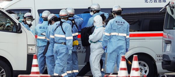 Пожарные в защитных костюмах помещают в машину скорой помощи заболевших пассажиров круизного лайнера Diamond Princes, помещенного в карантин у японского порта Йокогама - Sputnik Узбекистан