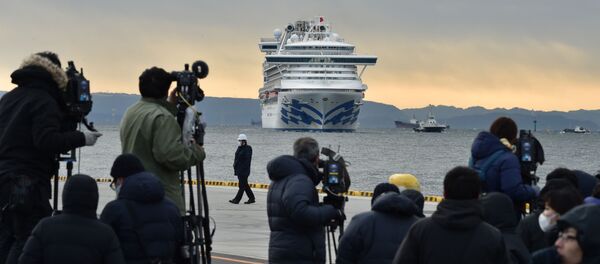 Фотографы и корреспонденты на фоне круизного лайнера Diamond Princes, помещенного в карантин у японского порта Йокогама - Sputnik Узбекистан
