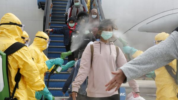 Медики опрыскивают индонезийских граждан антисептиком после прибытия из китайского Уханя, центра эпидемии коронавируса - Sputnik Ўзбекистон