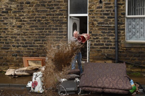 Мужчина чистит дом после наводнения в Северной Англии  - Sputnik Узбекистан