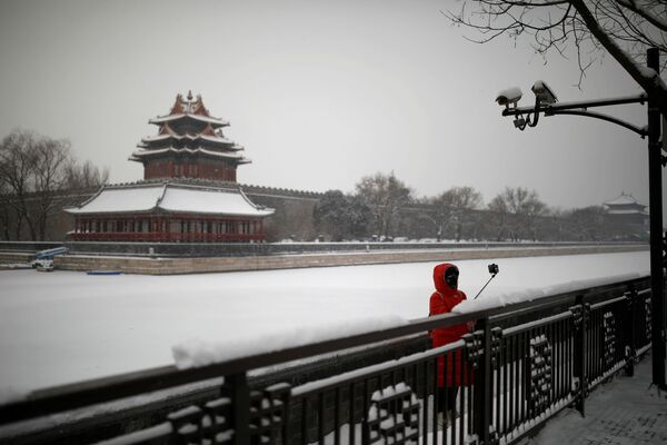 Туристов и местных жителей на улицах почти нет. Девушка в маске во время селфи у Запретного города в Пекине  - Sputnik Узбекистан