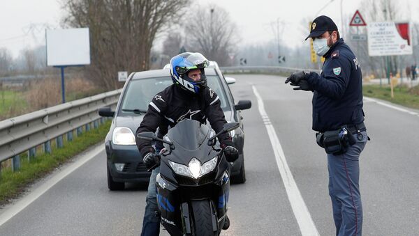 Полицейские в масках предупреждают водителей на дороге между Кодоньо и Казальпустерленго, которая была закрыта итальянским правительством из-за вспышки коронавируса на севере Италии  - Sputnik Ўзбекистон