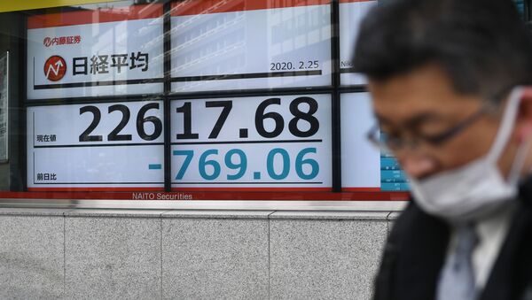 Пешеход в маске проходит мимо электрического табло котировок, на котором 25 февраля 2020 года на Токийской фондовой бирже был показан индекс Nikkei 225. - Токийские акции упали более чем на 3,5% на открытии 25 февраля 2020 - Sputnik Ўзбекистон