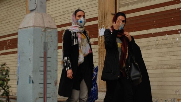 Жители Тегерана идут по одной из центральных улиц в медицинских масках - Sputnik Ўзбекистон
